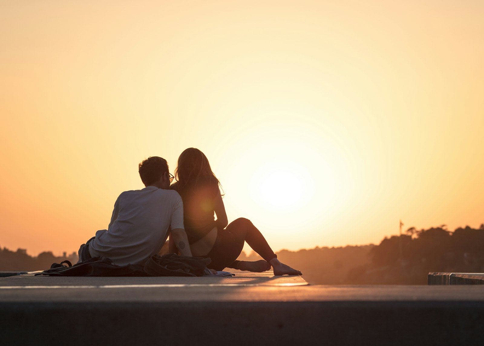 A couple sitting together outdoors in the evening light