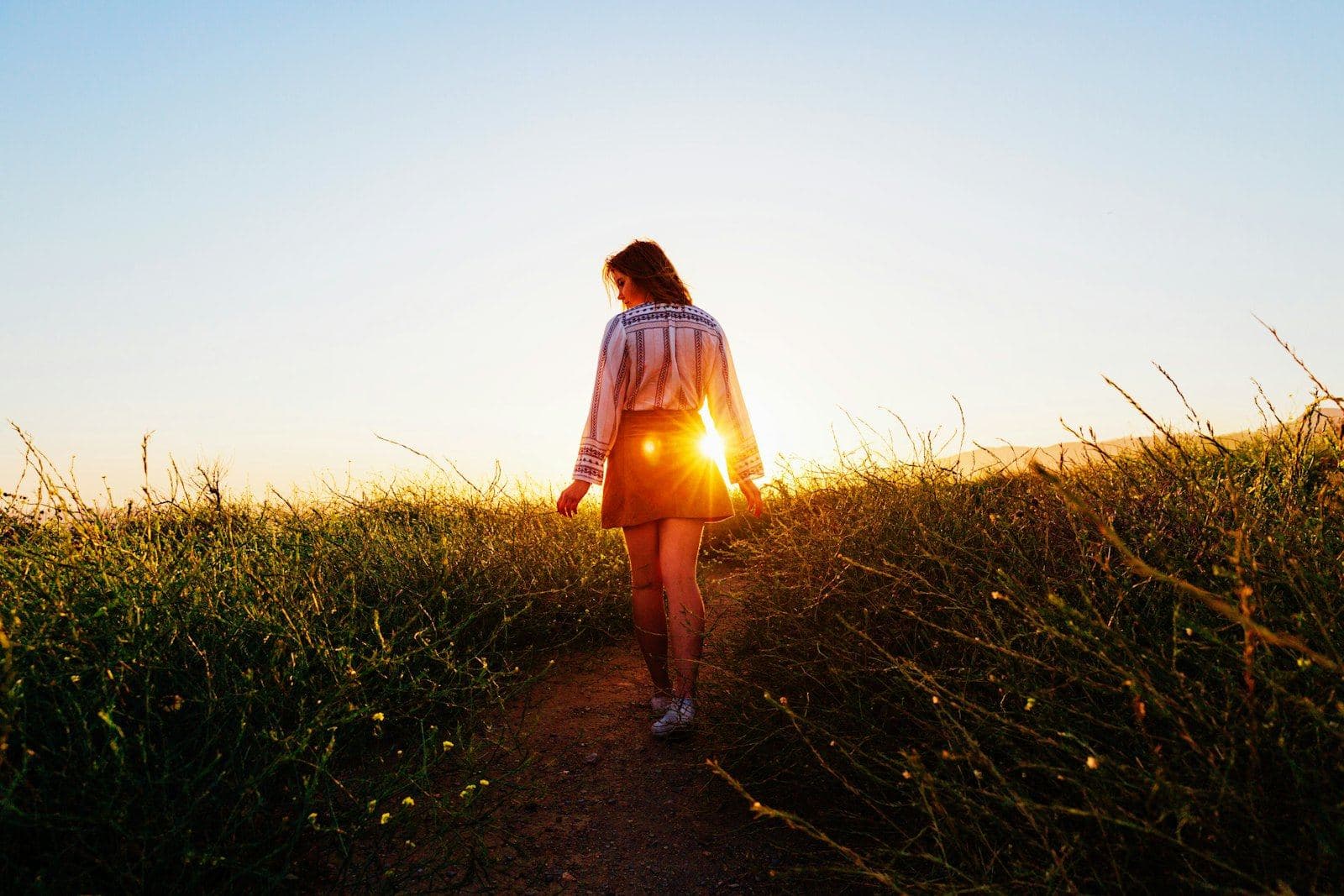 A woman walking along a path in soft golden light