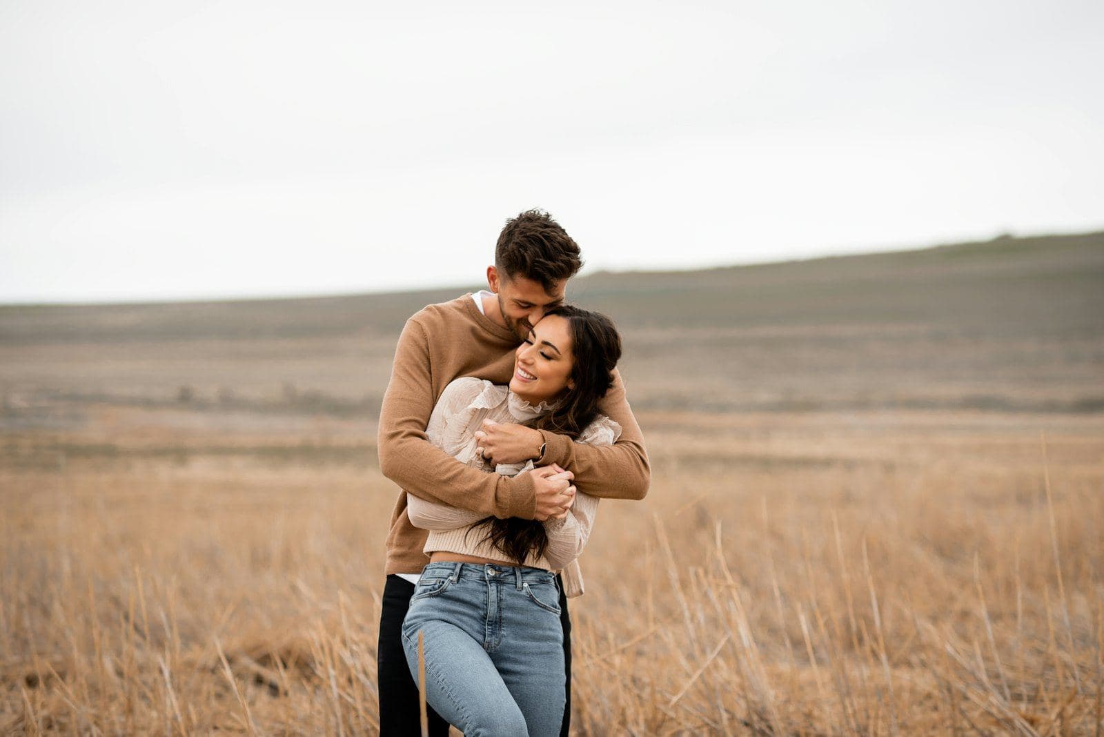 A couple embracing in a field of tall grass