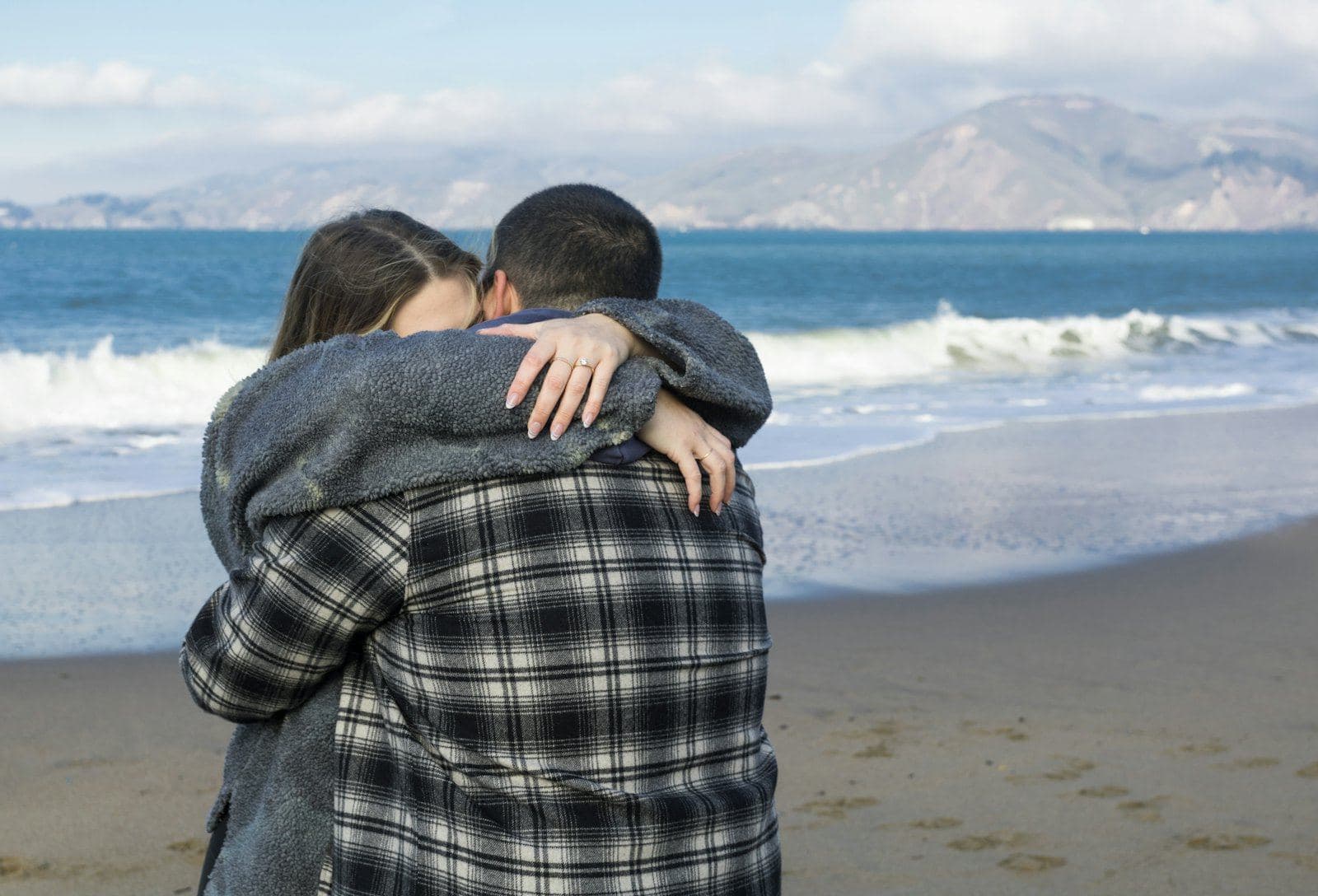 A couple holding each other on a beach