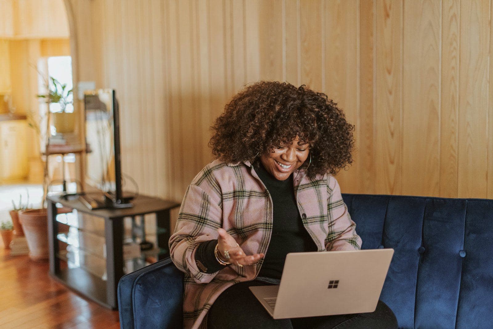 A woman on a sofa at home using a laptop for a video call