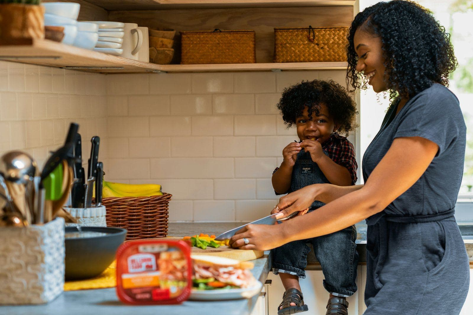 A mother cooking in the kitchen with her young children