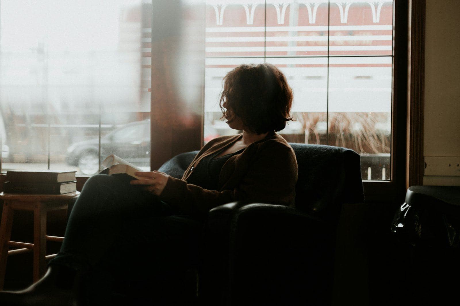 A woman sitting quietly by a large window