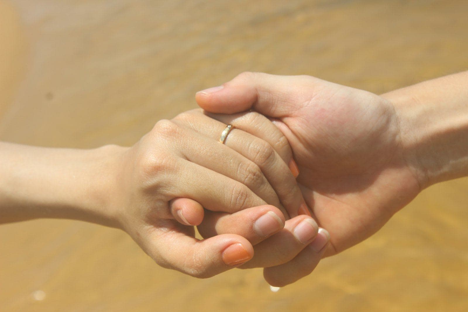 Two hands gently holding each other