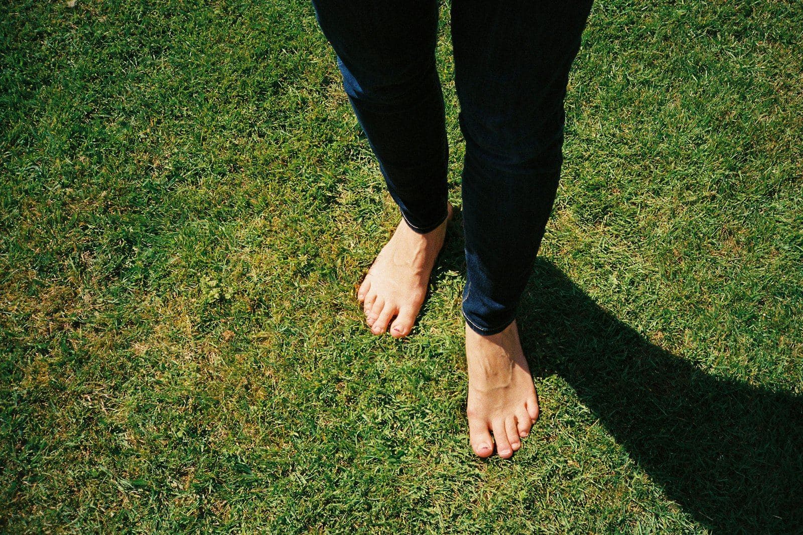 Bare feet standing on green grass