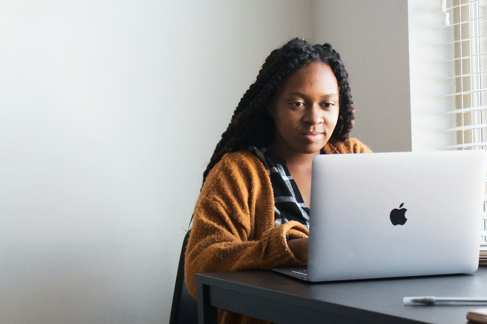 A woman smiling at her laptop while researching