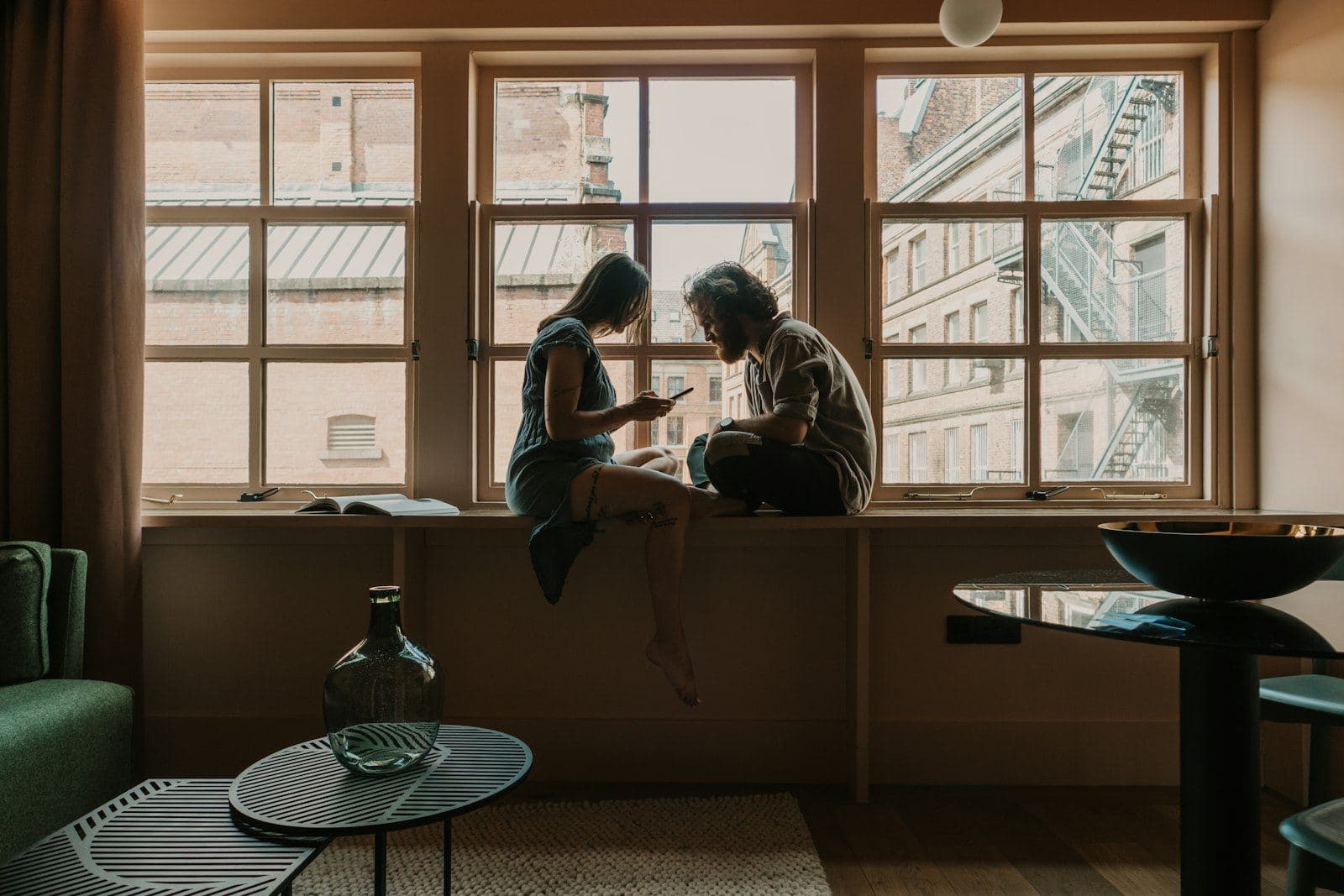 A couple sitting together on a wide window ledge