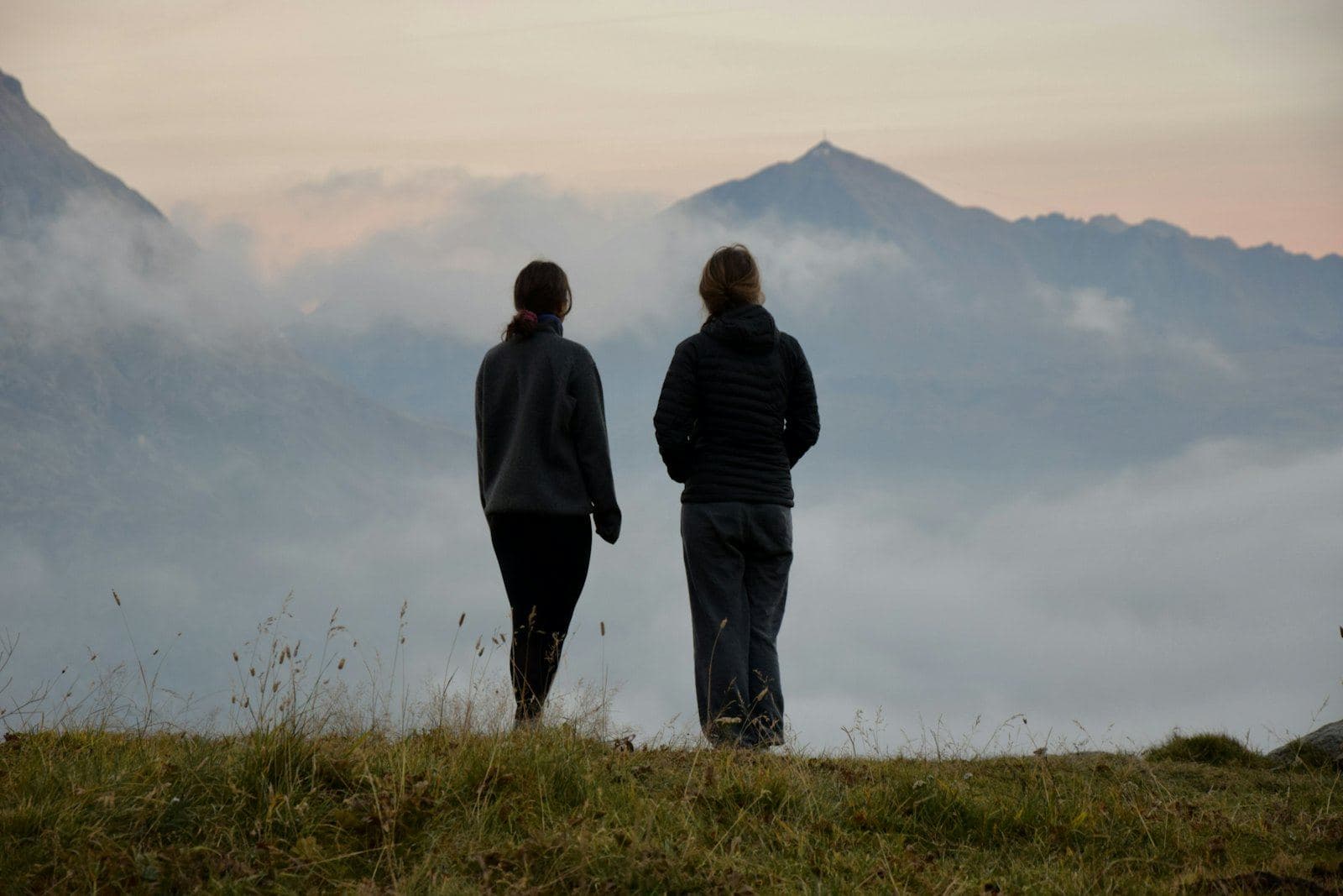 Two people standing together looking out over misty mountains