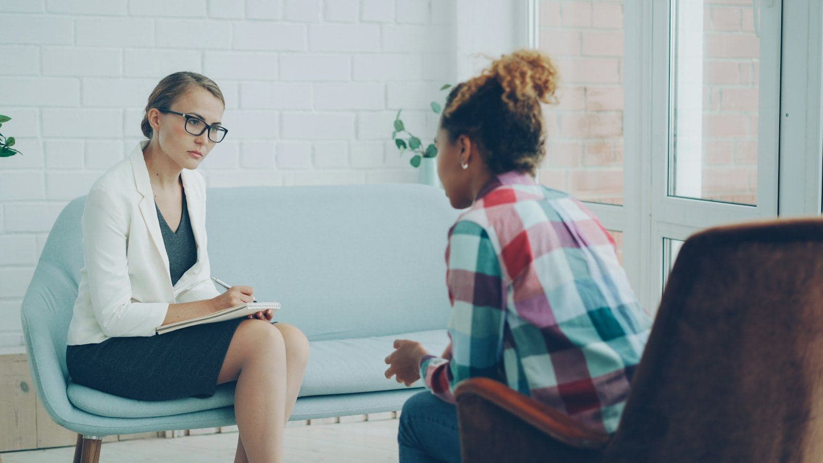 A therapist listening to a client in a bright office