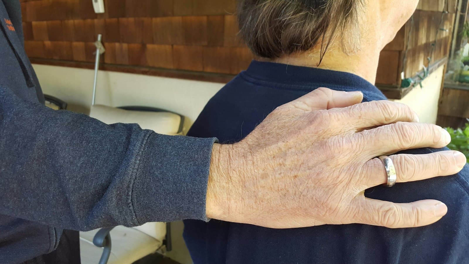 An older hand resting on someone's shoulder