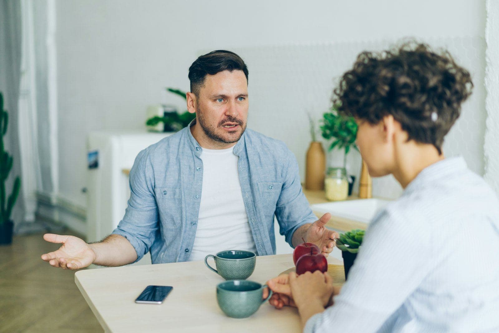 A couple talking over coffee at a small table