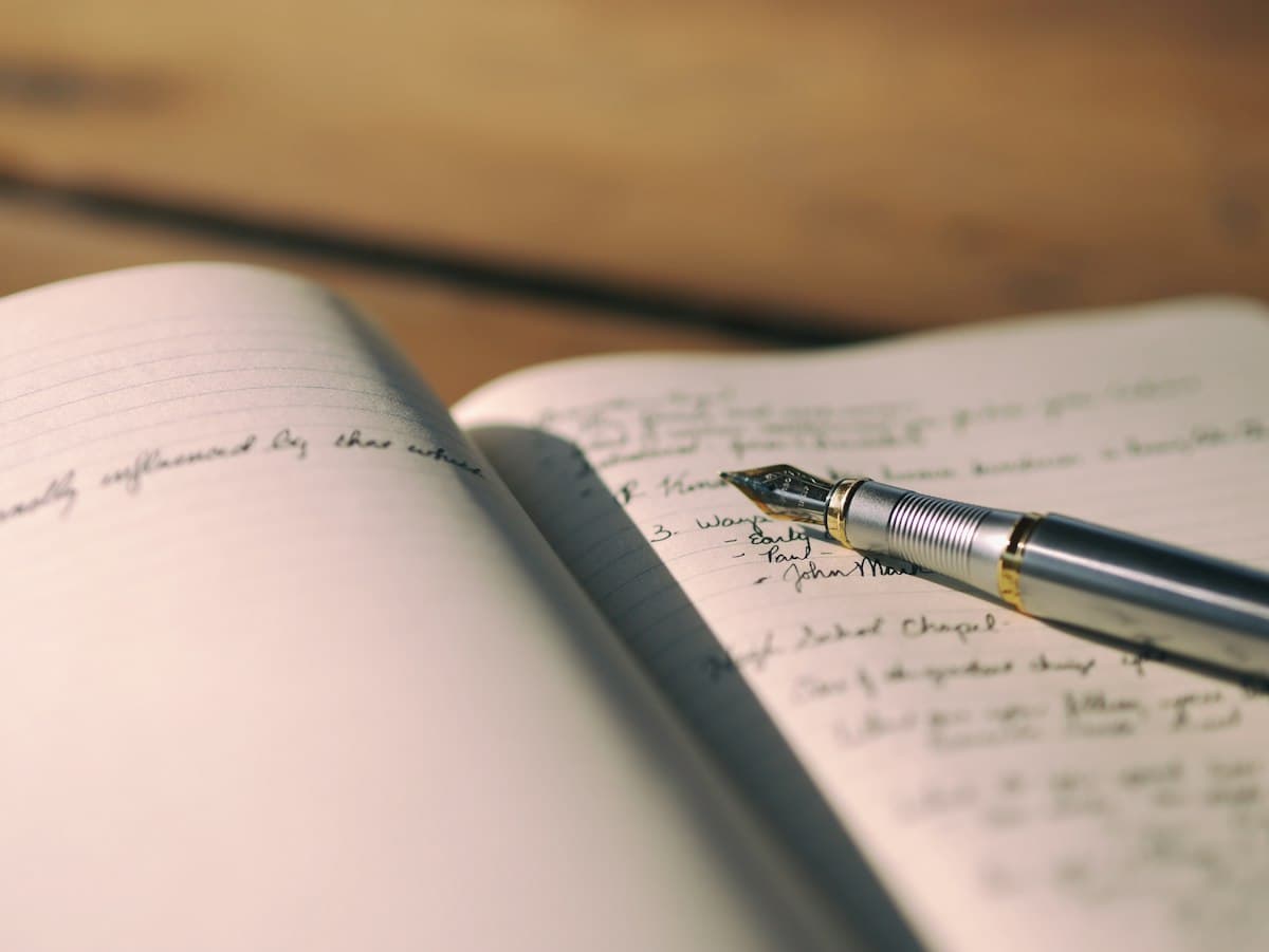 A fountain pen resting on an open handwritten journal